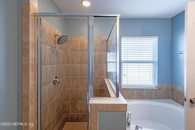 bathroom featuring shower with separate bathtub and a textured ceiling