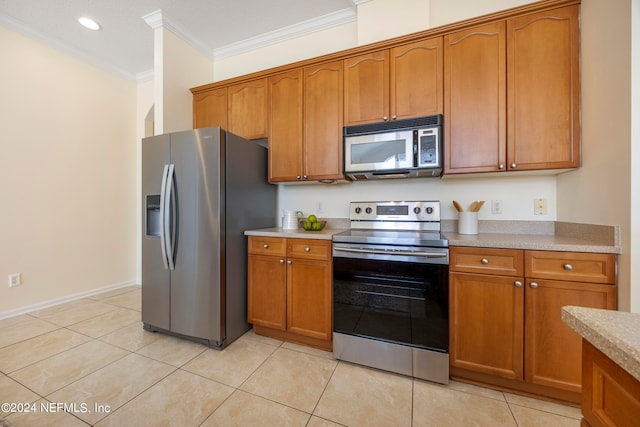 kitchen featuring ornamental molding, light tile patterned flooring, and stainless steel appliances