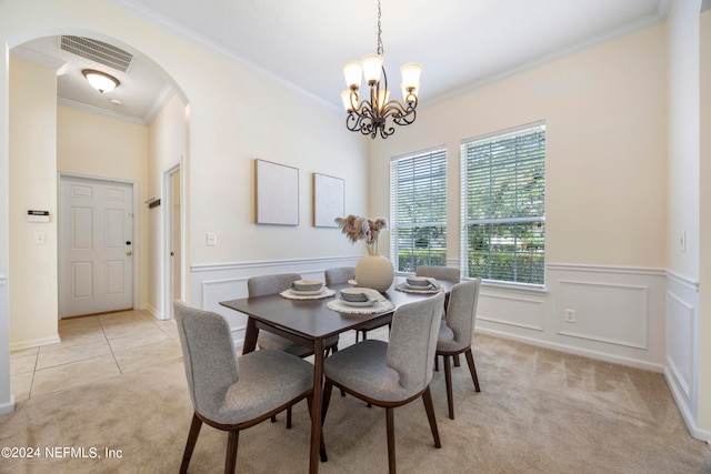 carpeted dining area featuring crown molding and a notable chandelier