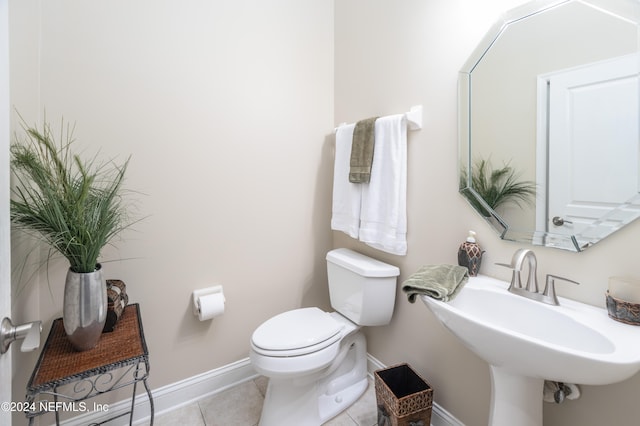 bathroom featuring tile patterned flooring, baseboards, a sink, and toilet