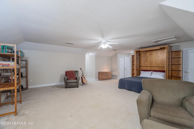 bedroom with a textured ceiling, light colored carpet, a ceiling fan, baseboards, and visible vents