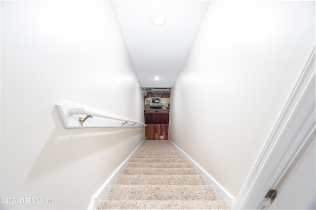 staircase featuring carpet and baseboards