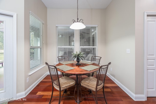 dining area with dark wood-type flooring and baseboards