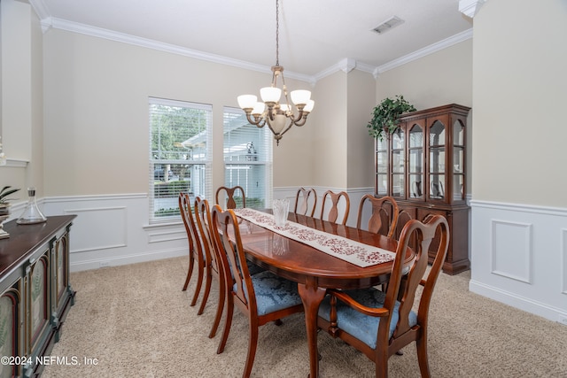 dining space with a wainscoted wall, a chandelier, and light colored carpet