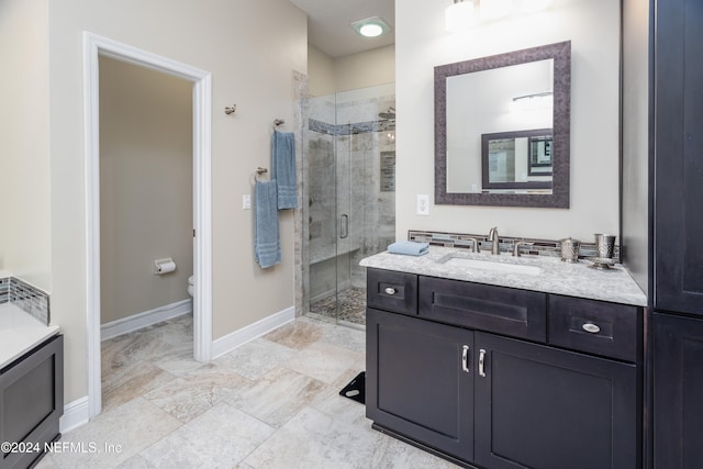 full bath with a stall shower, toilet, vanity, and baseboards