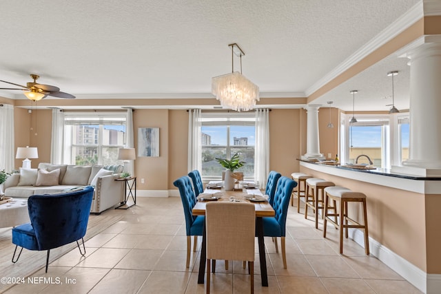 tiled dining space with a healthy amount of sunlight, a textured ceiling, and ceiling fan with notable chandelier