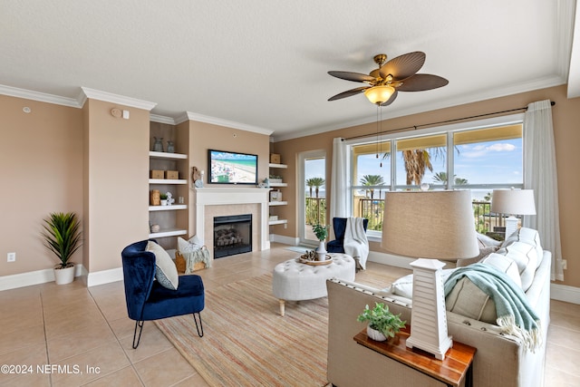 living room featuring light tile patterned flooring, a textured ceiling, a tile fireplace, ceiling fan, and built in shelves