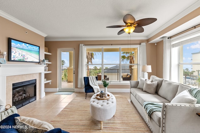 living room with a textured ceiling, light tile patterned flooring, a tiled fireplace, and a healthy amount of sunlight