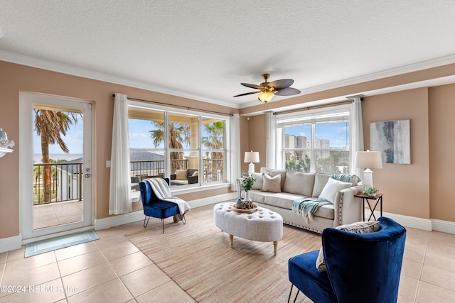 tiled living room with ceiling fan, a textured ceiling, ornamental molding, and plenty of natural light