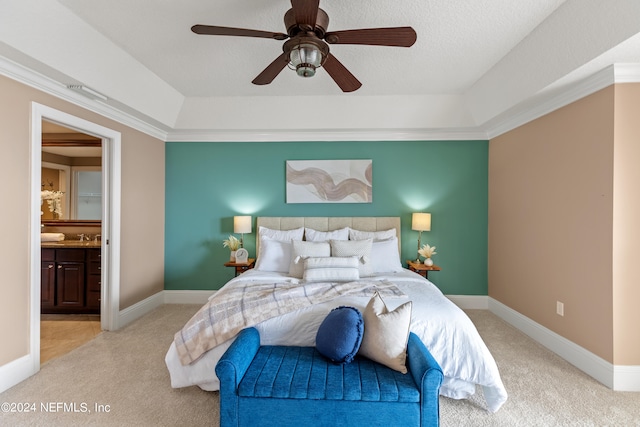 carpeted bedroom with connected bathroom, a tray ceiling, ornamental molding, a textured ceiling, and ceiling fan