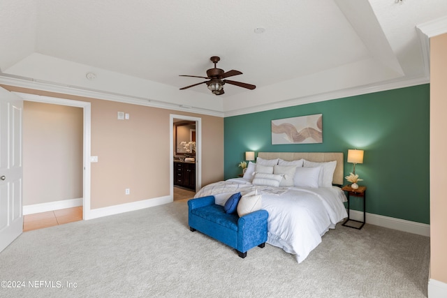 carpeted bedroom featuring connected bathroom, ornamental molding, ceiling fan, and a raised ceiling