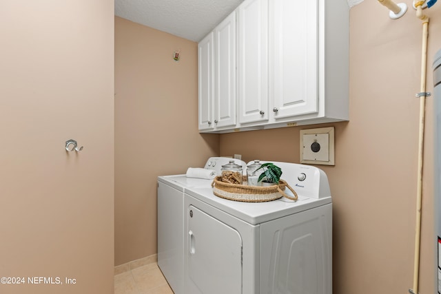 washroom featuring independent washer and dryer, a textured ceiling, cabinets, and light tile patterned floors