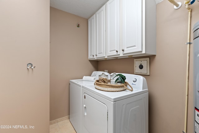 washroom featuring light tile patterned flooring, a textured ceiling, washer and clothes dryer, and cabinets