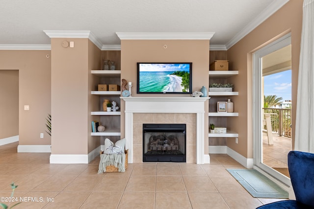 living room with light tile patterned floors, a textured ceiling, ornamental molding, a tile fireplace, and built in features