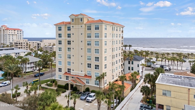 view of property with a water view and a beach view