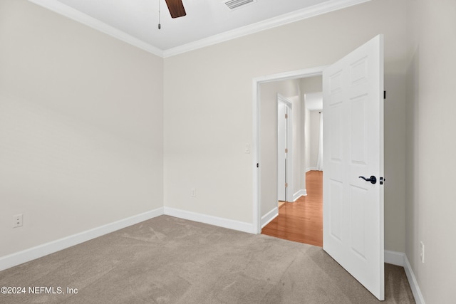 carpeted spare room featuring ceiling fan and ornamental molding