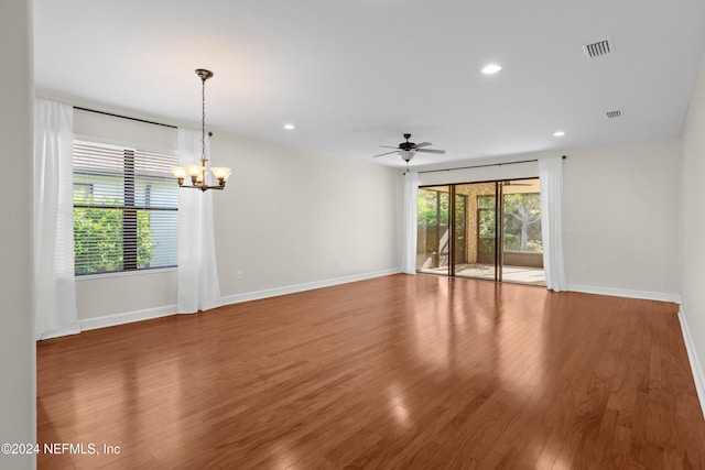 unfurnished room featuring hardwood / wood-style floors and ceiling fan with notable chandelier