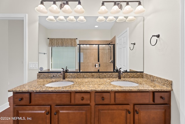 bathroom featuring a shower with door and vanity