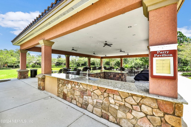 view of patio / terrace featuring an outdoor bar, ceiling fan, and an outdoor kitchen