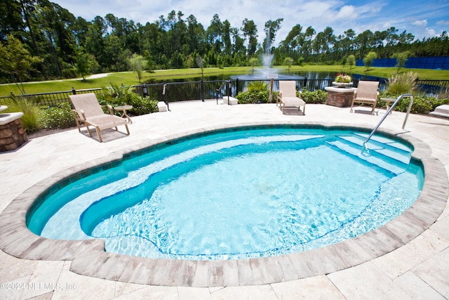 view of pool with a patio area and a water view