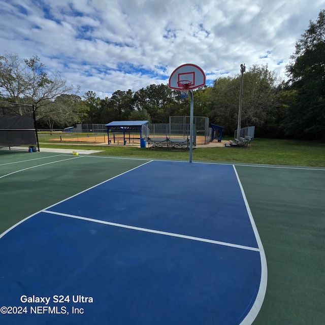 view of sport court with a lawn