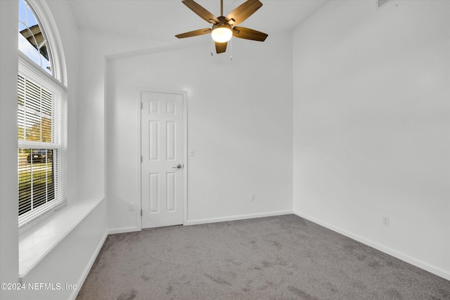 empty room featuring vaulted ceiling, ceiling fan, and carpet floors