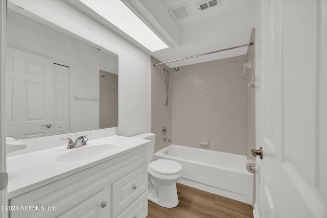 full bathroom featuring toilet, vanity, tiled shower / bath, and hardwood / wood-style floors