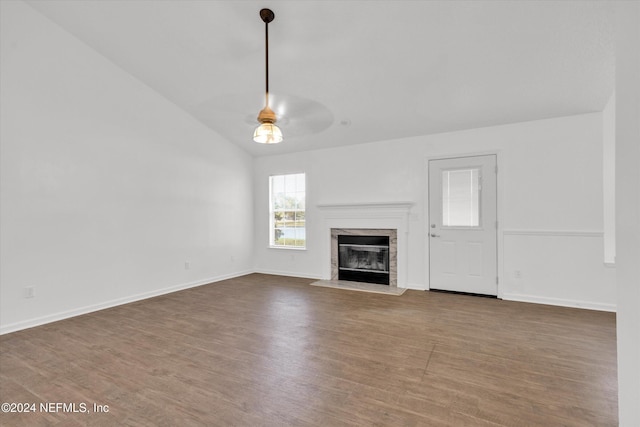 unfurnished living room with dark wood-type flooring, a fireplace, and vaulted ceiling