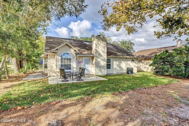 rear view of property featuring central AC unit, a yard, and a patio area