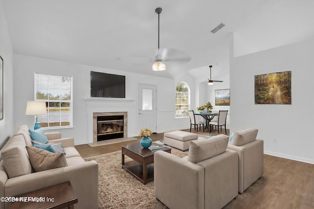 living room with light wood-type flooring, lofted ceiling, and ceiling fan