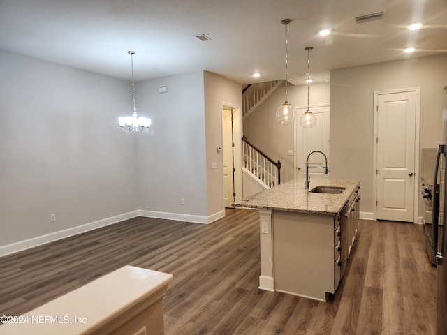 kitchen featuring a kitchen island with sink, sink, hanging light fixtures, and dark hardwood / wood-style floors