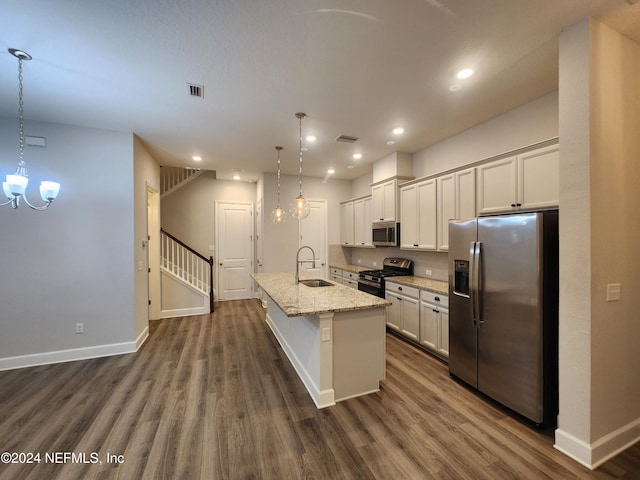 kitchen with sink, dark wood-type flooring, hanging light fixtures, a center island with sink, and appliances with stainless steel finishes