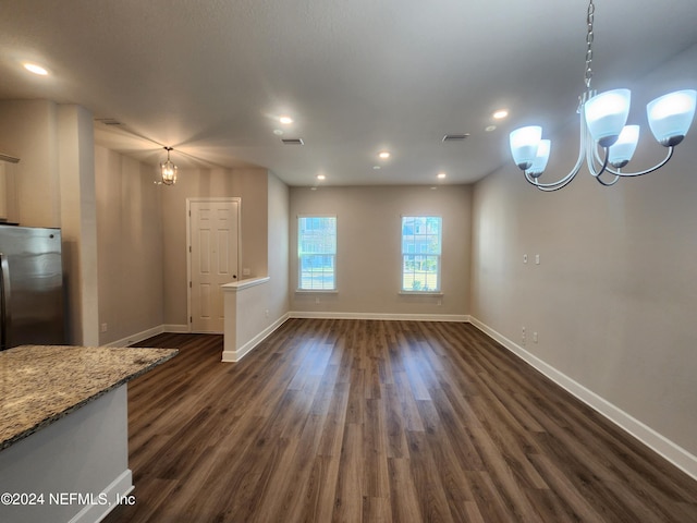 unfurnished dining area featuring dark hardwood / wood-style floors and a notable chandelier