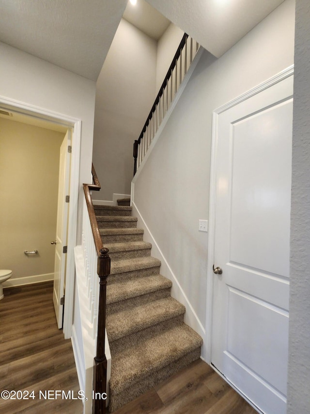 staircase with hardwood / wood-style floors