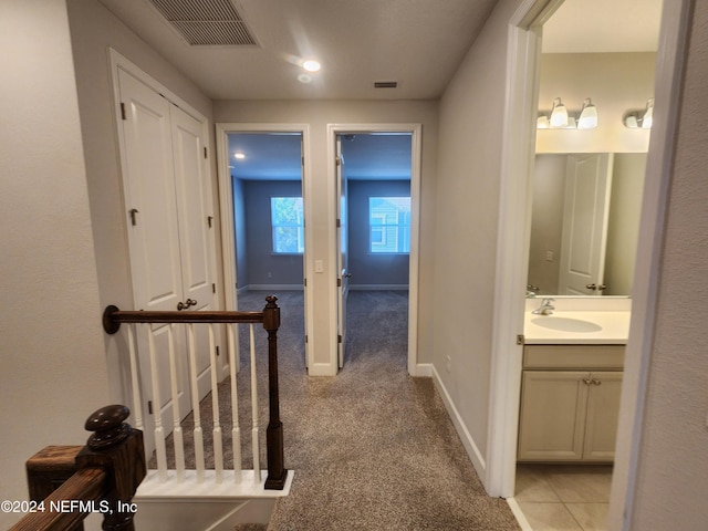 hall with light carpet and sink