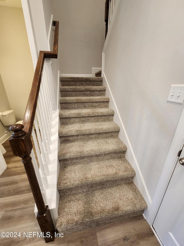 stairs featuring hardwood / wood-style flooring