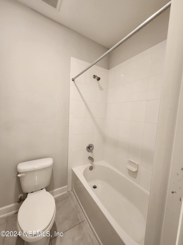 bathroom featuring tile patterned floors, tiled shower / bath combo, and toilet