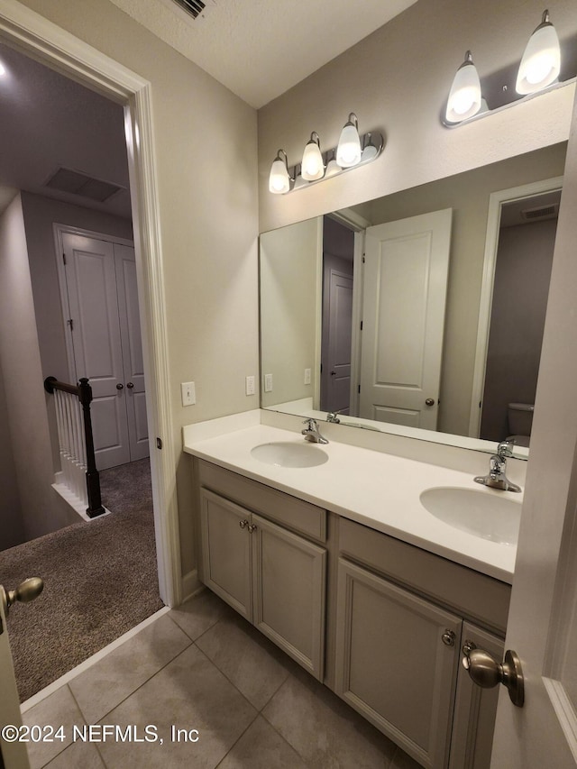 bathroom featuring tile patterned flooring, vanity, and toilet