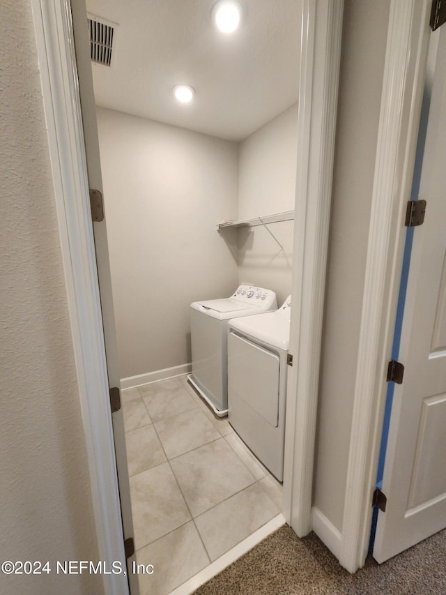 washroom with light tile patterned floors and washer and dryer