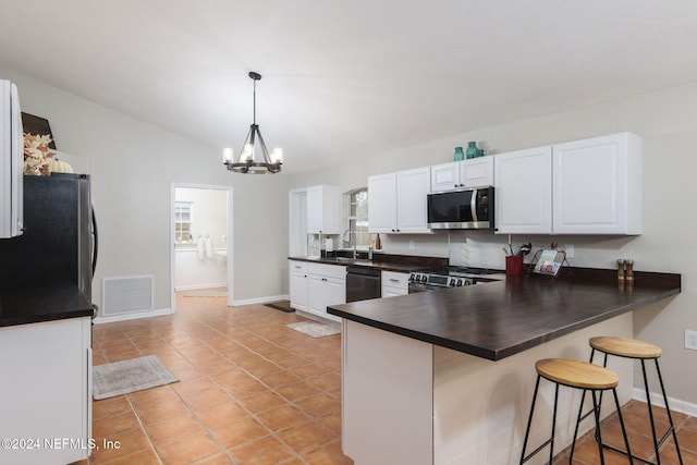 kitchen featuring appliances with stainless steel finishes, kitchen peninsula, a healthy amount of sunlight, and a breakfast bar area