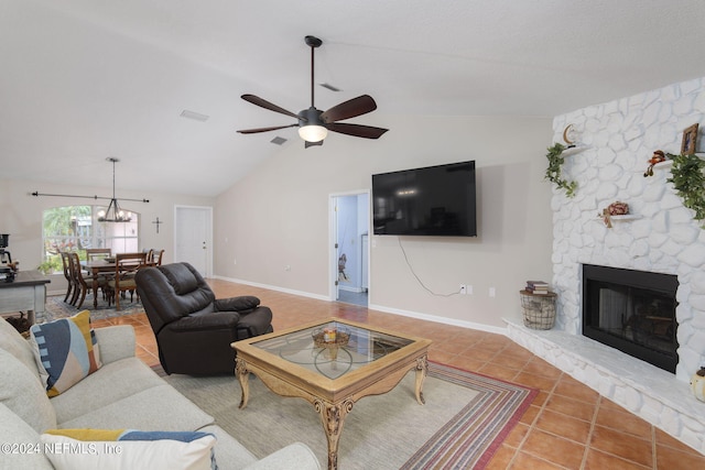 living room featuring ceiling fan with notable chandelier, vaulted ceiling, tile patterned flooring, and a fireplace