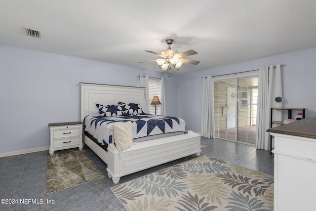 bedroom featuring ceiling fan, a textured ceiling, multiple windows, and access to exterior