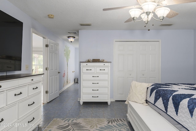 bedroom with a closet, ceiling fan, and a textured ceiling