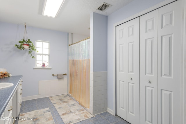 bathroom with vanity, tile patterned floors, and a textured ceiling