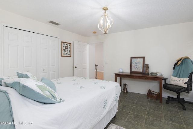 bedroom featuring a chandelier, a closet, and dark tile patterned flooring