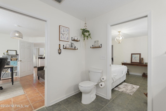 bathroom featuring tile patterned floors, a textured ceiling, and toilet