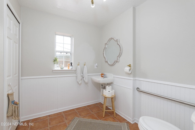 bathroom featuring tile patterned floors, a textured ceiling, and toilet