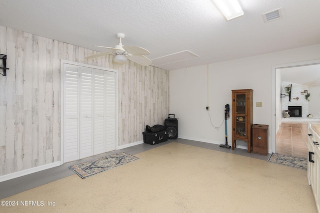 garage with ceiling fan and wood walls