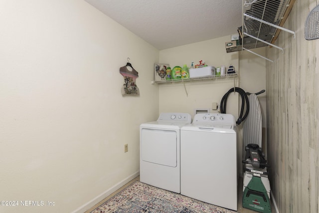 clothes washing area featuring independent washer and dryer and a textured ceiling