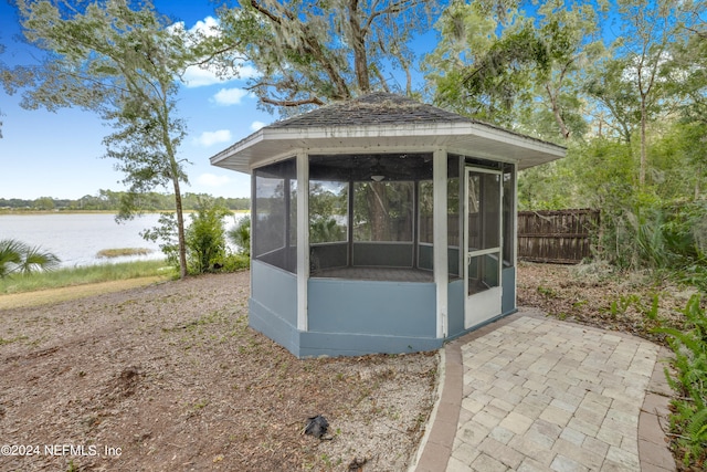 view of outbuilding with a gazebo, a sunroom, and a water view